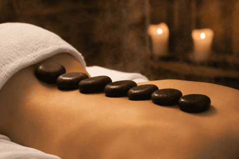 Técnica de masaje con piedras calientes en un ambiente relajante.