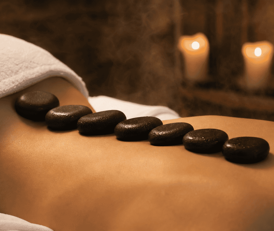 Técnica de masaje con piedras calientes en un ambiente relajante.